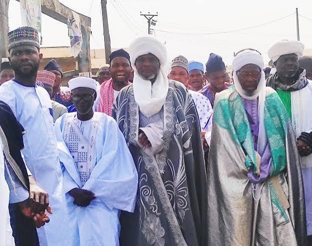 Clerics and elders in procession through the town on a festival morning.