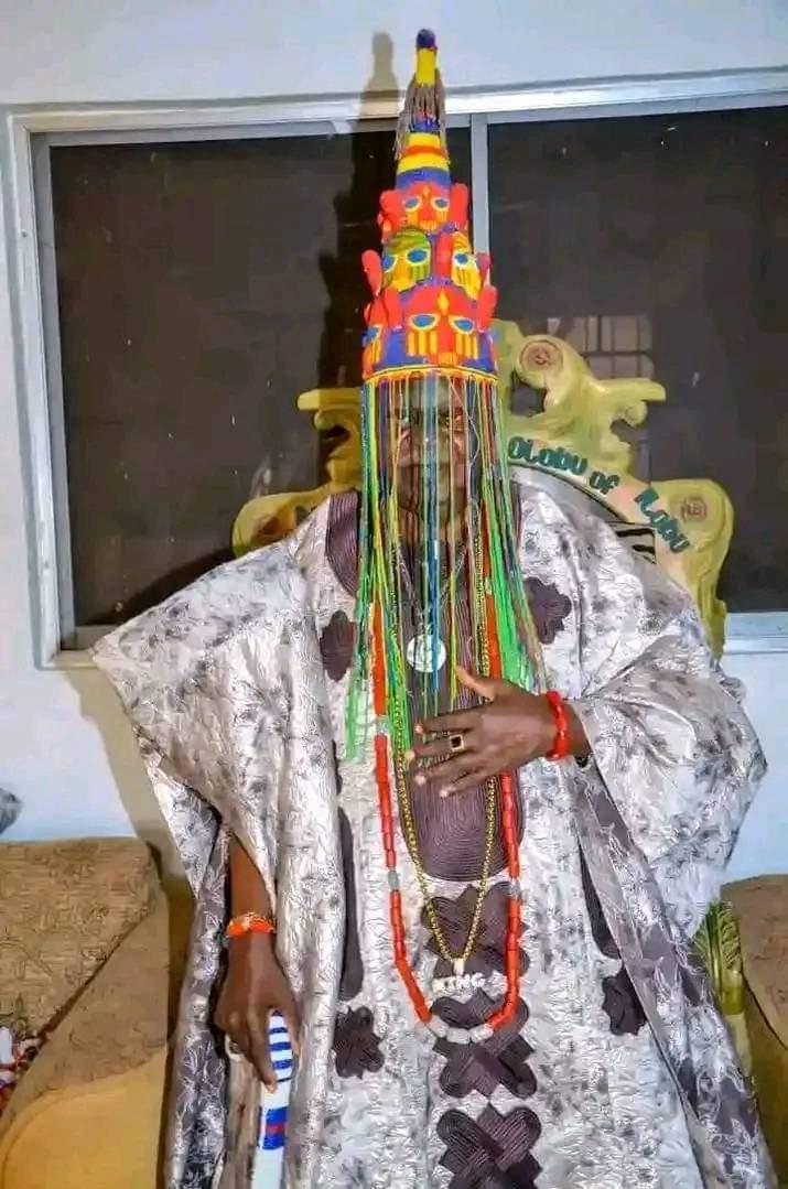 Ọba Asiru Olatoye Olaniyan II wearing the beaded crown of Ilobu, the veil drawn over his face.