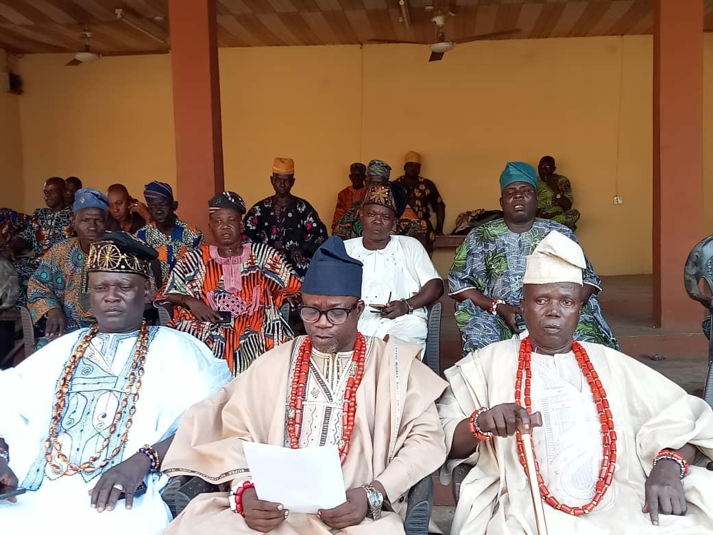 Chiefs of Ilobu seated in council, beads at the neck, a statement being read.