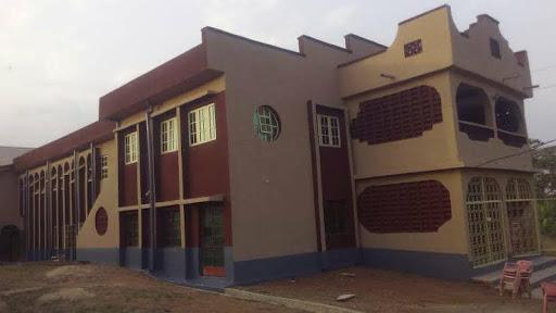 Ilobu House, the town hall — newly rendered, its arched windows set into a deep red and ochre facade.